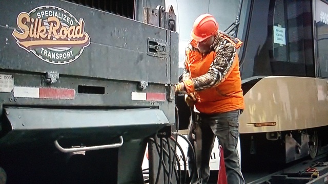 <p><strong>Silk Road crewman pulls out equipment&nbsp;to offload the 83,000-pound car onto tracks near the Amtrak station in Milwaukee.</strong></p>