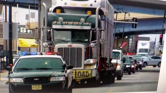 <p><strong>Police and pilot cars escort the rig carrying the first car for Milwaukee's new light-rail system to its drop-off point on March 26. </strong><em>Images: screen captures from Fox6 News-Milwaukee video.</em></p>